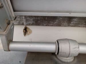 Unas tuberías de metal junto a una pared albergan un pequeño nido de pájaro cómodamente alojado en una grieta, que recuerda a los intrincados diseños que se pueden ver en Grandval Náutico.