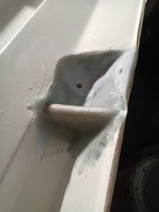 Primer plano de una reparación de fibra de vidrio sobre una superficie blanca en Grandval Náutico, con una sección saliente y textura visible, mostrando un mantenimiento experto de barcos en Barcelona.