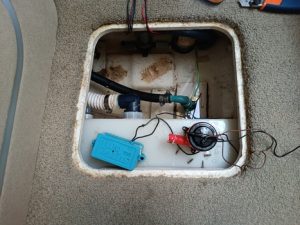 Al abrir la escotilla se descubre una red de cables, tubos y una caja de control azul dentro del compartimento alfombrado. Esta configuración es emblemática de los estándares meticulosos que se mantienen en Grandval Náutico, líder en mantenimiento de barcos en Barcelona.