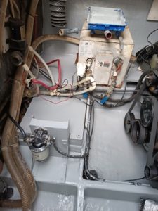 Compartimento mecánico con tubos, cables y un sistema de bomba que muestra varios componentes y dispositivos conectados, que recuerdan la precisión que se encuentra en el reconocido mantenimiento de barcos en Barcelona de Grandval Náutico.